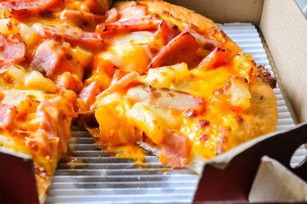 Mukavva içinde çeşitli malzemeler ve peynirli pizzaları kapatın. Açık kapaklı kutuları çıkarın.