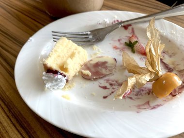 Restoranda yedikten sonra kirli tabaklar, çatal ve bir bardak buzlu kahvenin olduğu bir masanın üst görüntüsü. Karışıklık konsepti, kirli bulaşıklar. Sağlığa zararlı..