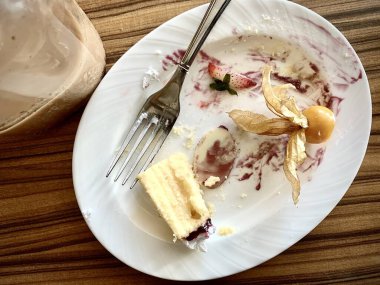 Restoranda yedikten sonra kirli tabaklar, çatal ve bir bardak buzlu kahvenin olduğu bir masanın üst görüntüsü. Karışıklık konsepti, kirli bulaşıklar. Sağlığa zararlı..