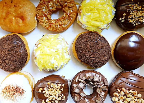 Glazed Donut Grubu 'nu tepsiye koy, lezzetli çoklu çeşitlilikte donut, seçici bir şekilde donut ye..