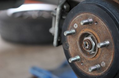 Otomobil tamircisi yeni lastik değiştirme sürecinde, garajda araba freni tamiri, tekerleği sökülmüş bir arabanın frenleri, garajda araba freni parçası, tekerlekleri olmayan bir araba fren diski. 