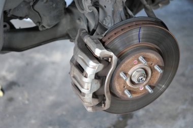 Otomobil tamircisi yeni lastik değiştirme sürecinde, garajda araba freni tamiri, tekerleği sökülmüş bir arabanın frenleri, garajda araba freni parçası, tekerlekleri olmayan bir araba fren diski. 