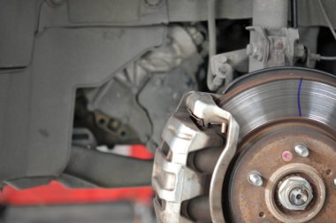 Otomobil tamircisi yeni lastik değiştirme sürecinde, garajda araba freni tamiri, tekerleği sökülmüş bir arabanın frenleri, garajda araba freni parçası, tekerlekleri olmayan bir araba fren diski. 