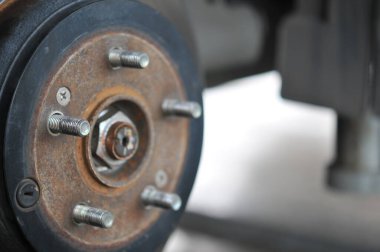 Otomobil tamircisi yeni lastik değiştirme sürecinde, garajda araba freni tamiri, tekerleği sökülmüş bir arabanın frenleri, garajda araba freni parçası, tekerlekleri olmayan bir araba fren diski. 