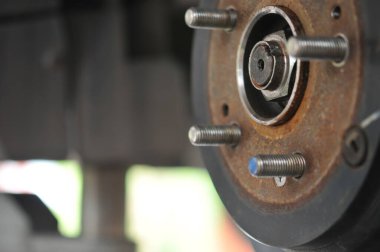 Otomobil tamircisi yeni lastik değiştirme sürecinde, garajda araba freni tamiri, tekerleği sökülmüş bir arabanın frenleri, garajda araba freni parçası, tekerlekleri olmayan bir araba fren diski. 