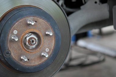 Otomobil tamircisi yeni lastik değiştirme sürecinde, garajda araba freni tamiri, tekerleği sökülmüş bir arabanın frenleri, garajda araba freni parçası, tekerlekleri olmayan bir araba fren diski. 