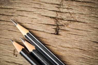 Tahta bir arka planda keskin bir kalem. Ahşap arka plan ofis malzemeleri ve okul öğrenimi üzerine kalem,