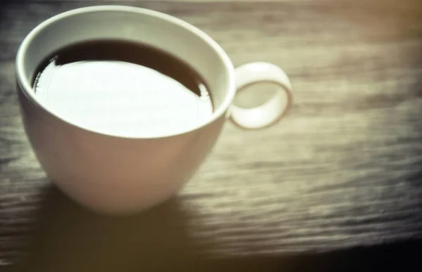 杯子木制质感上的咖啡杯 模糊的 白色的咖啡杯 在一杯黑咖啡中反射太阳光 — 图库照片