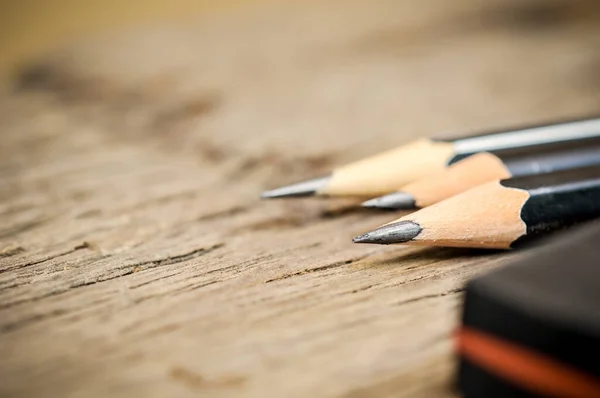 Tahta bir arka planda keskin bir kalem. Ahşap arka plan ofis malzemeleri ve okul öğrenimi üzerine kalem,