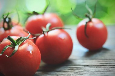 Domatesler, eski ahşap masada korunması için pişirildi. Organik yiyecekler, tahtada vişneli domatesler. Üzümlü ve sulu domatesler..