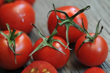 Domatesler, eski ahşap masada korunması için pişirildi. Organik yiyecekler, tahtada vişneli domatesler. Üzümlü ve sulu domatesler..