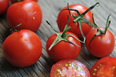 Domatesler, eski ahşap masada korunması için pişirildi. Organik yiyecekler, tahtada vişneli domatesler. Üzümlü ve sulu domatesler..
