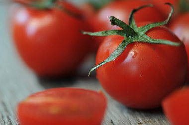 Domatesler, eski ahşap masada korunması için pişirildi. Organik yiyecekler, tahtada vişneli domatesler. Üzümlü ve sulu domatesler..