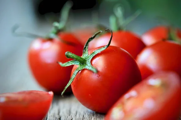 Domatesler, eski ahşap masada korunması için pişirildi. Organik yiyecekler, tahtada vişneli domatesler. Üzümlü ve sulu domatesler..