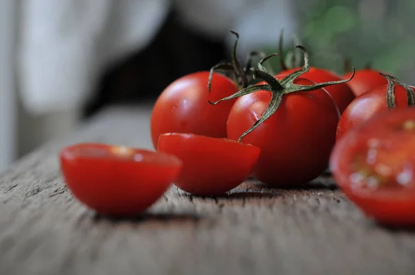Domatesler, eski ahşap masada korunması için pişirildi. Organik yiyecekler, tahtada vişneli domatesler. Üzümlü ve sulu domatesler..