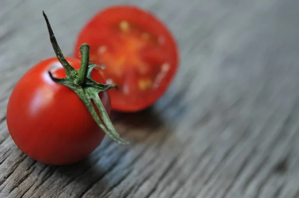 Tomatoes, cooked for the preservation on the old wooden table. Organic food, Cherry tomatoes on wood. Cherry tomatoes on vine with water drops.