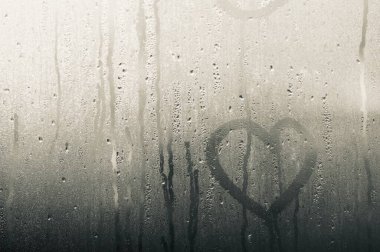 Şeffaf cam ve bir damla su var ve dışarıdaki camın arkasını görebiliyor ama net değil. Yağmur yağdığında aynada buhar ya da buhar