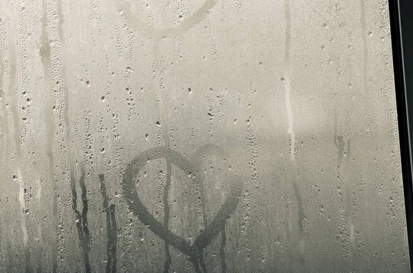 Şeffaf cam ve bir damla su var ve dışarıdaki camın arkasını görebiliyor ama net değil. Yağmur yağdığında aynada buhar ya da buhar