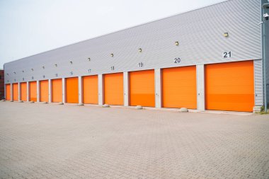 Turuncu tekerlekli kapılı ticari bir deponun dışı.