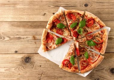 Sıcak ve lezzetli pizza bir ahşap arka plan üzerinde yemeye hazır. Hedef
