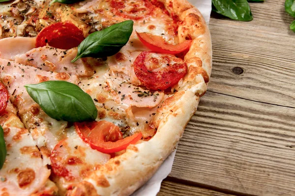 Pizza caliente y sabrosa lista para comer sobre un fondo de madera . — Foto de Stock