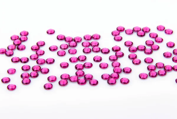 Değerli köpüklü rhinestones renkler beyaz bir arka plan üzerinde yükseldi.