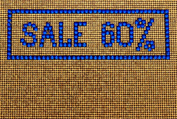 Word SALE is made rhinestones blue color on a gold canvas backgr — Stock Photo, Image