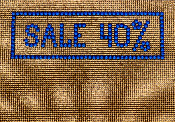 Word SALE está hecho de diamantes de imitación de color azul en un fondo de lona dorada —  Fotos de Stock