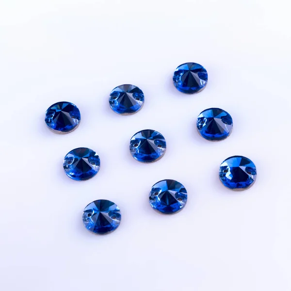 Precious stones of sapphire color of round shape on a white back