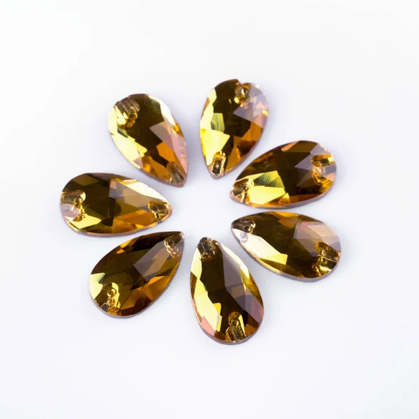 Precious stones yellow color in the shape a tear drop on a white
