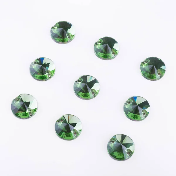 Драгоценные камни зеленого цвета круглой формы на белой спине — стоковое фото