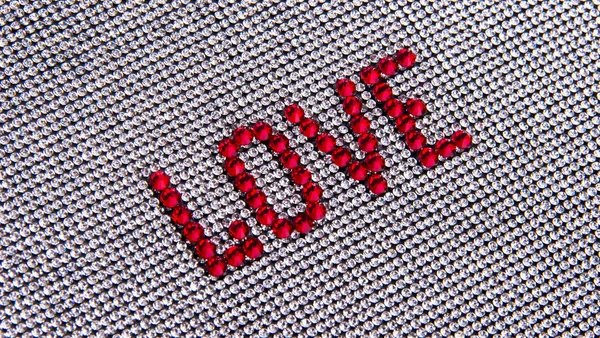 Kelime aşk arka plan bez rhinestones bir kristal üzerinde yapılan.