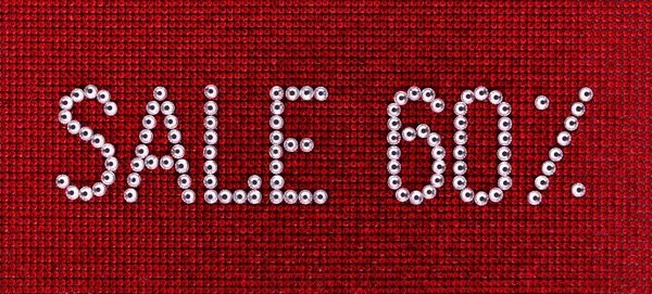 Word SALE is made rhinestones crystal color on a red canvas back — Stock Photo, Image