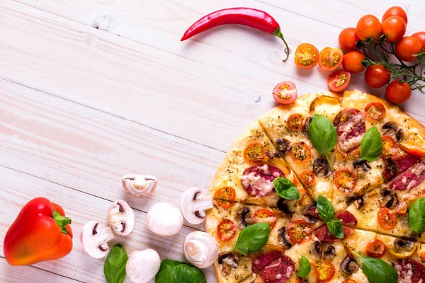 Salam sebze ve baharatlar ile pizzaya beyaz bir ahşap arka plan kopya alanı ile.