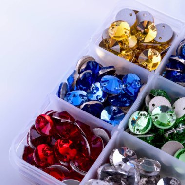 Parlak renkli rhinestones beyaz zemin üzerinde bir kutu şeklinde yuvarlak.