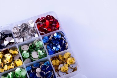 Parlak renkli rhinestones beyaz zemin üzerinde bir kutu şeklinde yuvarlak.
