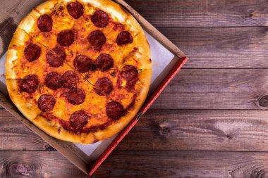 Pizza salam kopya alanı ahşap bir zemin üzerine bir kutu içinde. Üstten Görünüm.