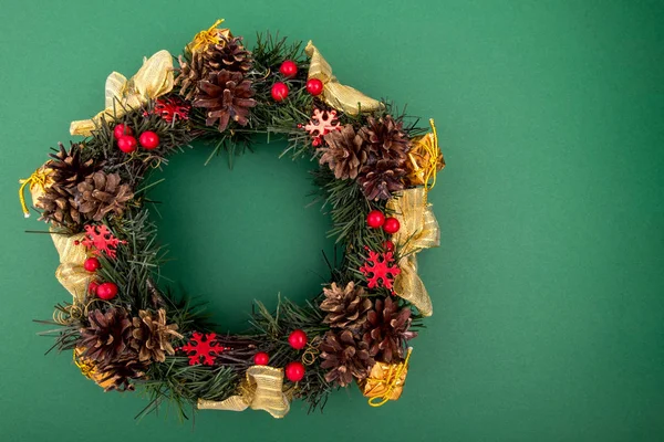 Corona de Navidad, Composición de vacaciones sobre un fondo verde. Vista superior . — Foto de Stock