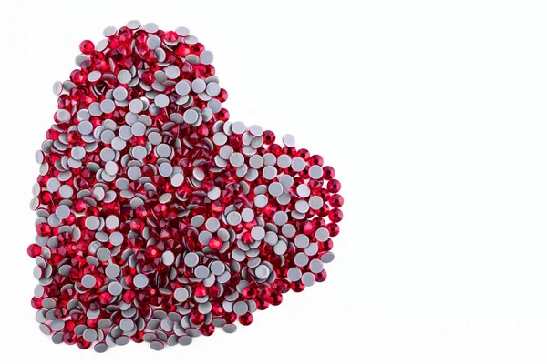 Πολλή κόκκινη στρας με το σχήμα μιας καρδιάς σε λευκό φόντο. Το Top view. — Φωτογραφία Αρχείου