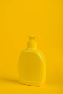 Kozmetik şişe üzerinde sarı arka plan izole.