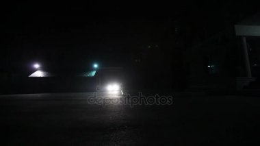 Gece, ışıklar Parlatıcı binaya araba sürmek, araba içinde belgili tanımlık yarda, geceleri araba farlar araba farlar çağırır.