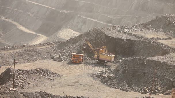 Pelle et benne à ordures dans la carrière, Grande pelle jaune chargée de minerai dans une benne à ordures — Video