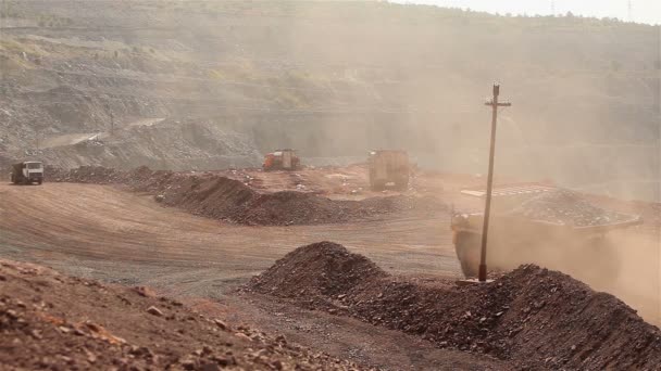 Un gran volquete cava a través de una carrera, un camión industrial draga carga en su cantera, un gran volquete amarillo — Vídeos de Stock