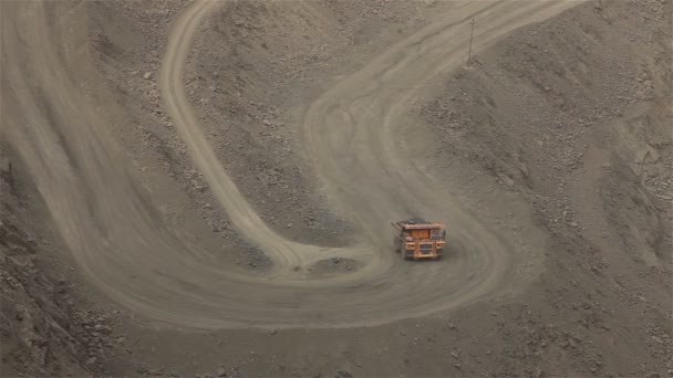 Een grote Kipper graaft door een carrière, een industriële vrachtwagen baggert lading in de steengroeve, een grote gele dumper — Stockvideo