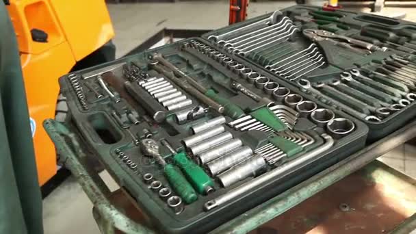 Um conjunto de chaves para reparar o carro repousa sobre a mesa de trabalho na oficina, a reparação de empilhadeiras na oficina — Vídeo de Stock