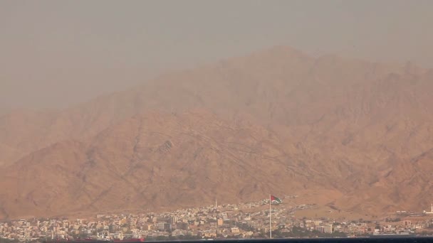 समुद्र दृश्य, पहाड़ों और पहाड़ के पैर पर शहर की पृष्ठभूमि के खिलाफ, दुनिया का सबसे बड़ा ध्वज — स्टॉक वीडियो