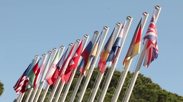 Banderas de colores que se balancean contra un cielo azul, Muchas banderas se balancean en el viento — Vídeo de stock