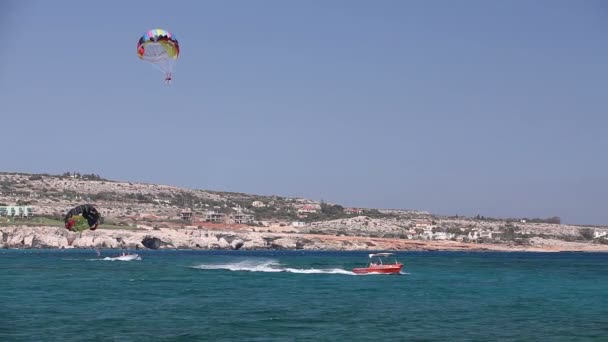 El barco enrolla a un hombre en un paracaídas, entretenimiento en el mar, hermosa costa, buen tiempo — Vídeos de Stock