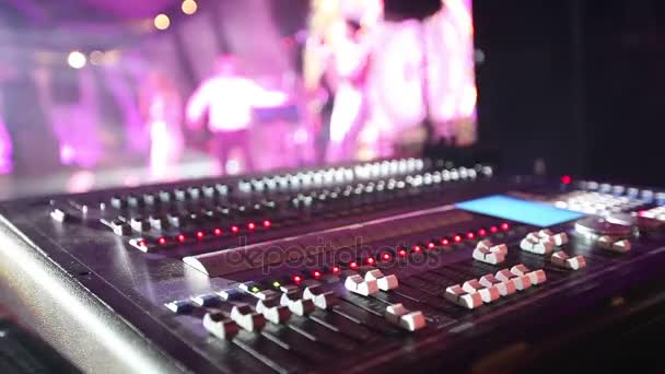 Soundman près de la console audio professionnelle dans un concert, console de mixage sonore pendant un concert, mixeur audio, ingénieur de contrôle, mise au point sélective, mixeur audio, sombre, faible profondeur de champ — Video
