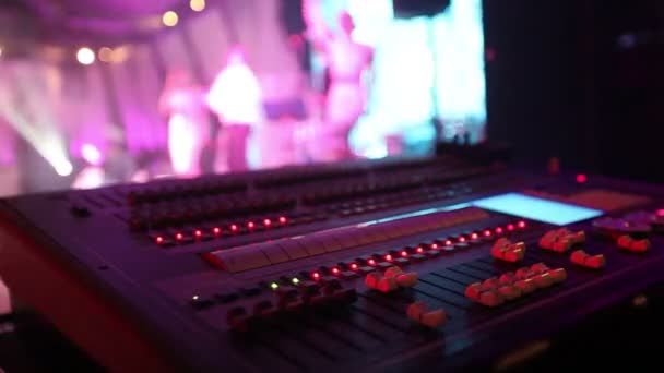 Soundman près de la console audio professionnelle dans un concert, console de mixage sonore pendant un concert, mixeur audio, ingénieur de contrôle, mise au point sélective, mixeur audio, sombre, faible profondeur de champ — Video